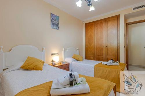 ein Hotelzimmer mit zwei Betten mit Handtüchern darauf in der Unterkunft 2 BDR apt with heated pool & jacuzzi in Benalmádena