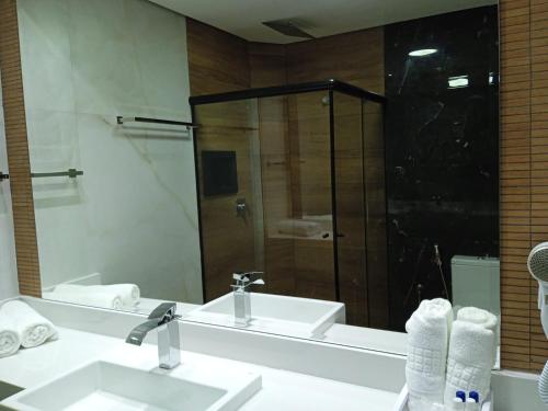 a bathroom with two sinks and a shower at Hotel Titanic Penedo in Penedo