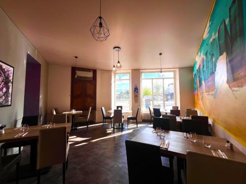 restauracja ze stołami i krzesłami oraz dużym obrazem na ścianie w obiekcie hotel restaurant le saint nazaire w mieście Saint-Nazaire-en-Royans