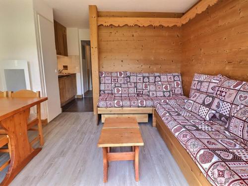 Cette chambre comprend un canapé et une table. dans l'établissement Appartement cosy, skis aux pieds, 4 pers., proche commerces et écoles de ski - FR-1-182-99, à Méribel