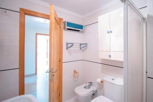 a white bathroom with a toilet and a sink at Combarro Port in Combarro