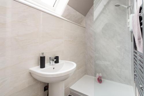 a white bathroom with a sink and a shower at Crown Street Aparthotel 2 in Halifax