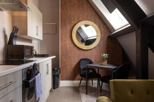 a kitchen with a mirror and a table with chairs at Crown Street Aparthotel 2 in Halifax