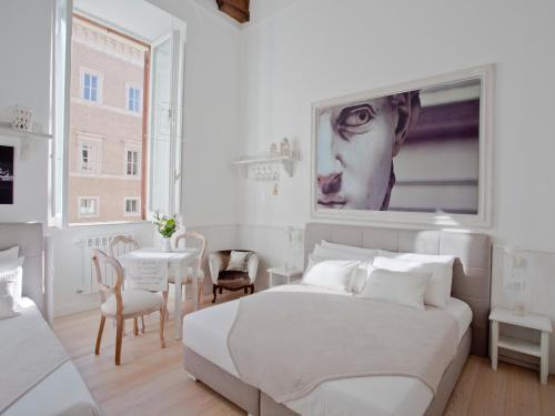 una camera bianca con un grande letto e un tavolo di Primo Piano Suites a Roma