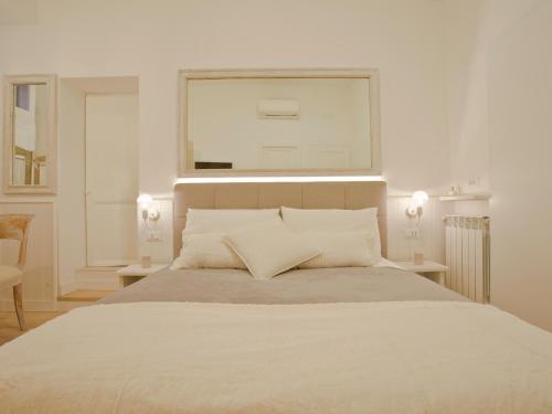 a white bedroom with a large bed with two tables at Primo Piano Suites in Rome