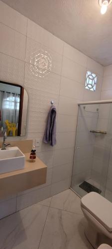 a bathroom with a sink and a shower and a toilet at Casa Aconchegante in Anchieta