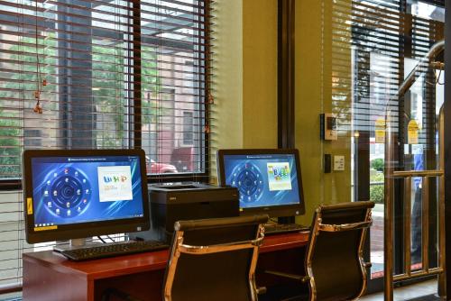 two computer monitors sitting on top of a desk at Holiday Inn Express Manhattan Midtown West by IHG in New York