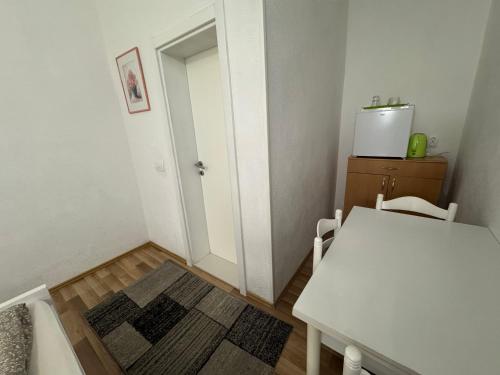 a small room with a table and a white door at Villa Anja Apartments in Mostar