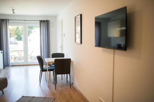 a dining room with a table and a television on the wall at HUGOS Studio Apartment in Bensheim
