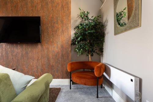a living room with a tv and a chair at Crown Street Aparthotel 2 in Halifax