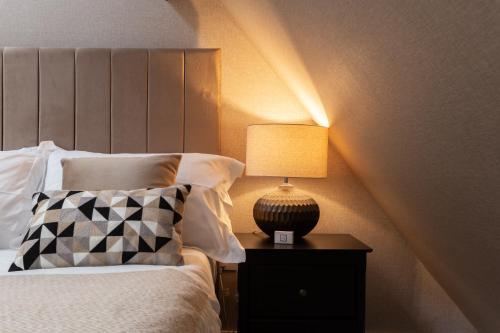 a bedroom with a bed with a lamp on a nightstand at Crown Street Aparthotel 2 in Halifax
