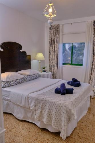 two beds in a bedroom with two blue towels on them at Casa Luisa in Teror