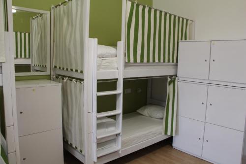 a bunk bed with white bunk beds in a room at Lorf Hostel&Coffee in Kraków