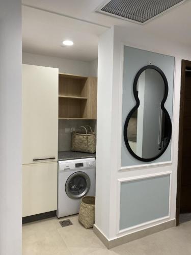 a bathroom with a washing machine and a mirror at PENTASQUARE Apartments by SUPERHOST STAYS in Lahore