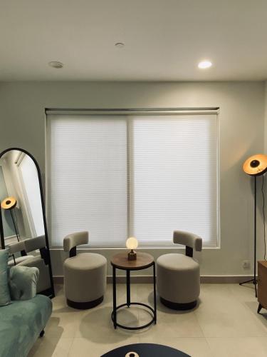 a living room with a couch and chairs and a window at PENTASQUARE Apartments by SUPERHOST STAYS in Lahore