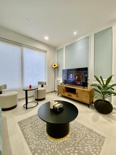 a large living room with a tv and a table at PENTASQUARE Apartments by SUPERHOST STAYS in Lahore
