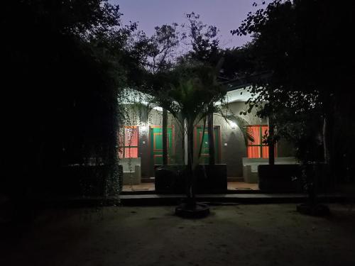 a house with brightly lit windows at night at Clay Hut Village in Polonnaruwa