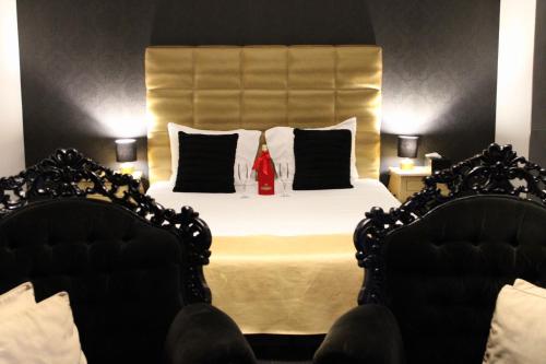 a bedroom with a large bed with two chairs at V E R O N E - Rooms & Suites - Liège - Rocourt in Liège