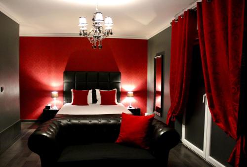 a bedroom with a bed with red walls and a black leather couch at V E R O N E - Rooms & Suites - Liège - Rocourt in Liège