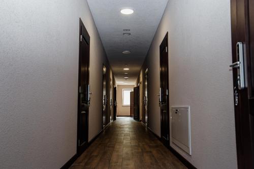 an empty hallway with doors and wooden floors at Новый хостел Nesvit Киев Академгородок in Kyiv
