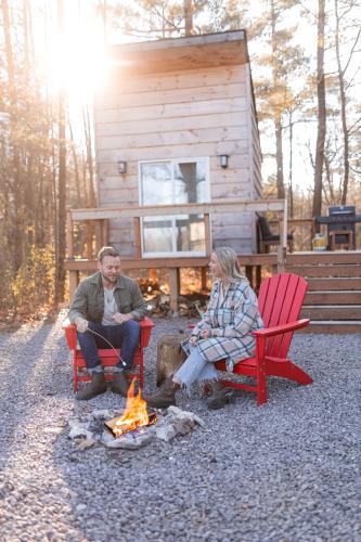 two people sitting around a fire in front of a cabin at The Green Acres Cabin in Hamilton