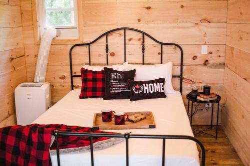 a bed in a cabin with a tray of food on it at The Green Acres Cabin in Hamilton