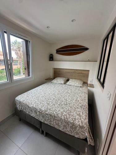une chambre avec un lit et deux fenêtres dans l'établissement T2 Hyeres La Bergerie vue mer 50 M de la plage, à Hyères