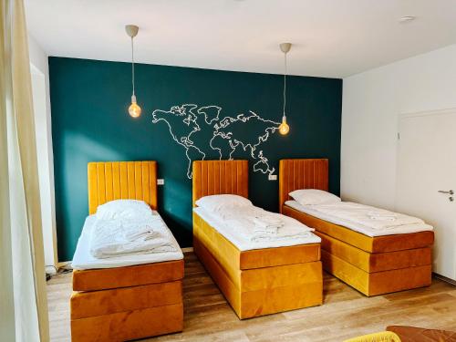 two beds in a room with a wall with a map at Jenapartments Design Loft, Damenviertel im Stadtzentrum in Jena