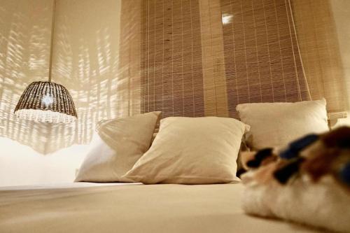 a bedroom with a bed with pillows and a lamp at Casa da Leoa in Sal Rei
