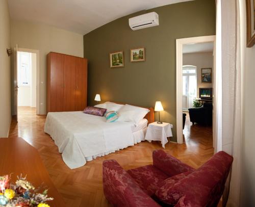 a bedroom with a white bed and a couch at Gianina Apartment in Split