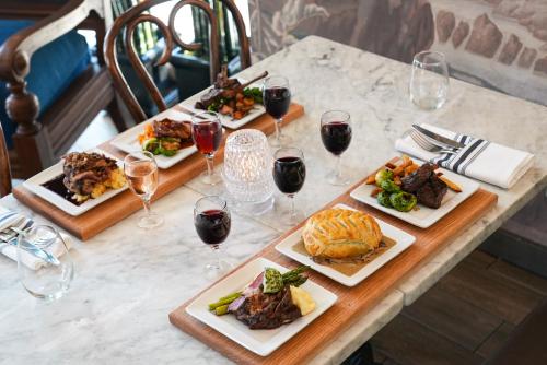 a table with three plates of food and glasses of wine at Porter Square Hotel in Cambridge