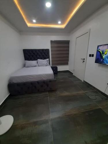 ein Schlafzimmer mit einem Bett in der Mitte eines Zimmers in der Unterkunft HOME AWAY FROM HOME SIMPLY tHE BEST 3 in Lekki Phase 1