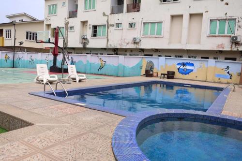 ein Schwimmbad vor einem Gebäude in der Unterkunft HOME AWAY FROM HOME SIMPLY tHE BEST 3 in Lekki Phase 1