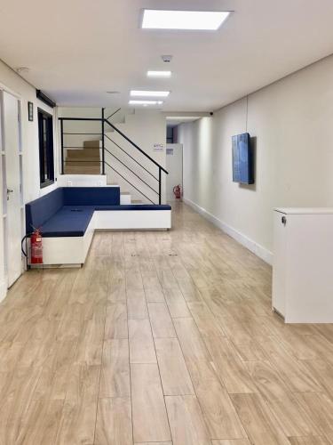 a room with a blue bed and a wooden floor at Quarto individual Vila Olimpia in Sao Paulo