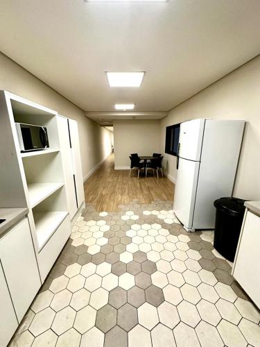 an empty room with a kitchen with a refrigerator at Quarto individual Vila Olimpia in Sao Paulo