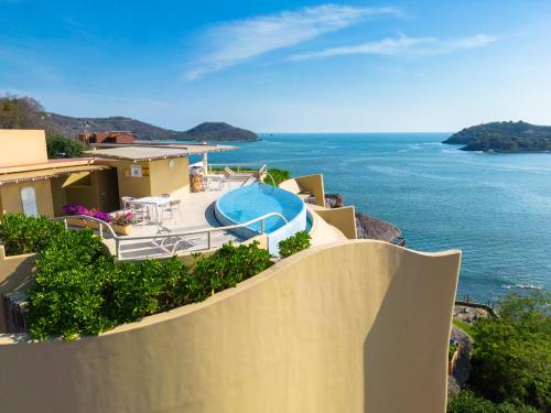 a house with a swimming pool and the ocean at Villas Kaukan by Tasman in Zihuatanejo