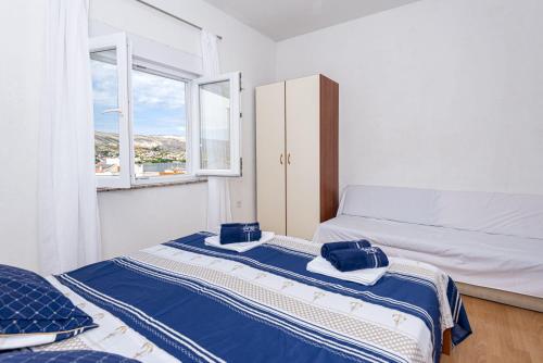 a small bedroom with a bed and a window at Vila Murvica in Pag