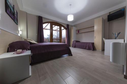 a bedroom with a bed and a large window at La Dolce Mela in Buonabitacolo