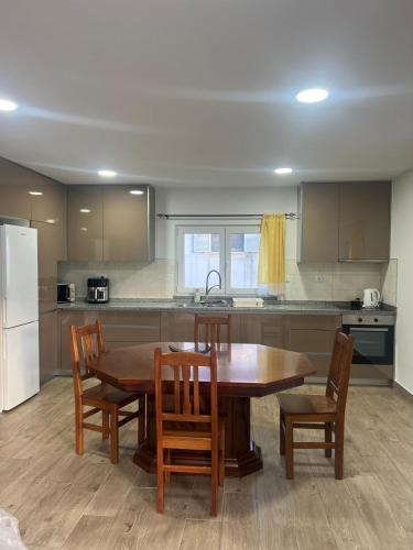 a kitchen with a wooden table and chairs and a kitchen with a refrigerator at Alojamentos da Aldeia in Vila de Rei