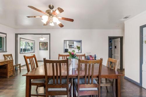 a dining room with a table and a ceiling fan at Spacious Home & Guest House, 2 Kitchen & Garden in Chico
