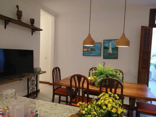 a living room with a dining room table and a television at Casa Boulevard 24 - Itaparica in Itaparica Town
