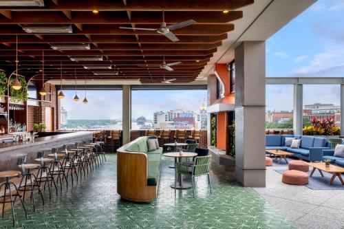 a restaurant with a bar with chairs and tables at The Alida, Savannah, a Tribute Portfolio Hotel in Savannah