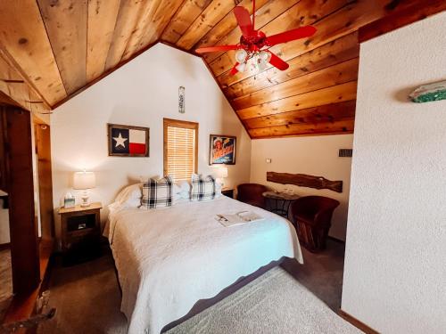 a bedroom with a bed with a ceiling fan at Gruene Cottages in New Braunfels