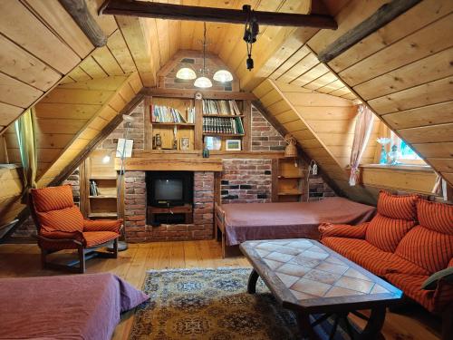 a attic room with two beds and a tv at Käbliku Puhkemajad in Kanepi