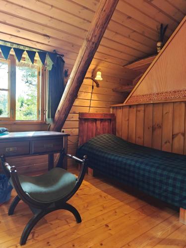 a bedroom with a bed and a desk and a chair at Käbliku Puhkemajad in Kanepi