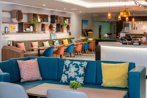 a blue couch in a restaurant with a bar at Holiday Inn Bristol Filton by IHG in Bristol