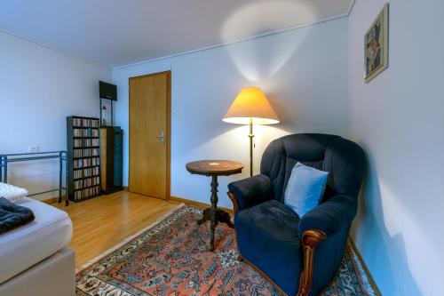 a living room with a chair and a table at Blattenheimat - im traditionellen Appenzeller Haus in Appenzell