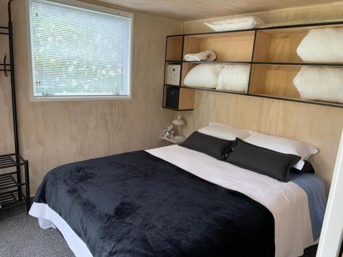 a bedroom with a large bed and a window at Herbert Hampden Cottage in Herbert