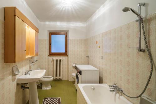 a bathroom with a sink and a tub and a toilet at Villa Chiappuzza - Stayincortina in San Vito di Cadore