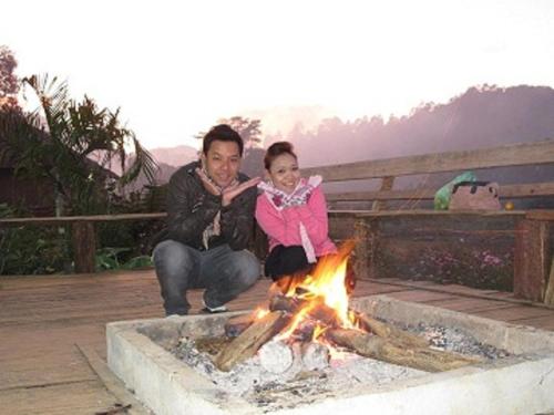 a man and a little girl sitting next to a fire at Mong Homestay Resort in Pang Ung